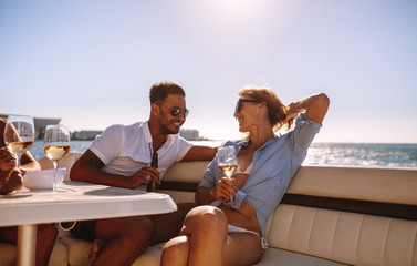 Smiling couple sitting on a boat with drinks