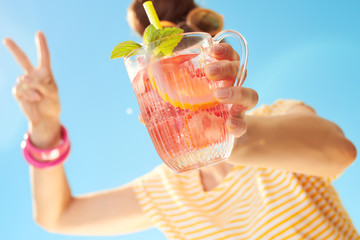 Closeup on cocktail in hands of young woman showing victory