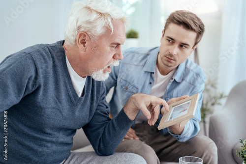 Фото: Memory loss. Ill senior man talking and man carrying photo Memory loss. Ill senior man talking and man carrying photo