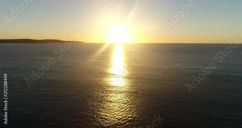 Видео: Rising hot sun over horizon of open sea from Australian continent facing Pacific ocean during aerial flying towards the Sun over calm morning water.
Rising hot sun over horizon of open sea from Australian continent facing Pacific ocean during aerial flying towards the Sun over calm morning water.