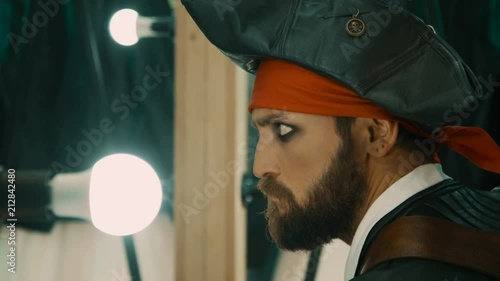 Видео: Bearded man in costume of pirate rehearsing facial expressions in front of mirror before performance or before shooting a movie Bearded man in costume of pirate rehearsing facial expressions in front of mirror before performance or before shooting a movie