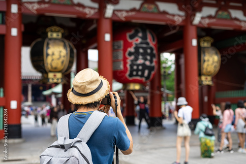 Plakat Młody podróżnik bierze fotografię Sensoji świątynia w Asakusa, Tokio, Japonia