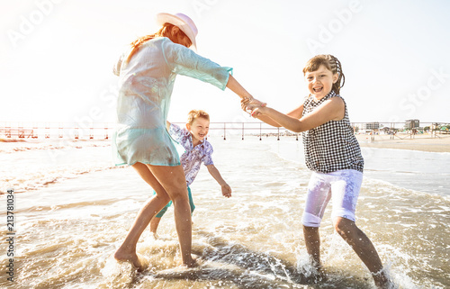 happy mom playing whit her children with the sea happy mom playing whit her children with the sea