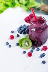 Smoothie berry bottle on white wooden board