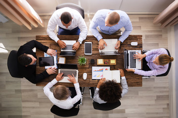 Group Of Businesspeople Working On Laptop