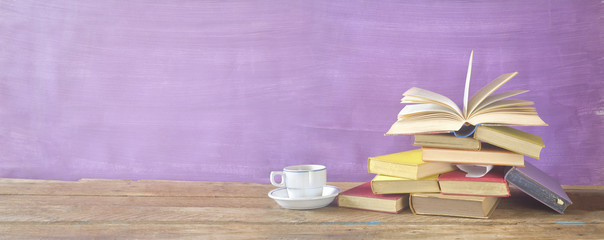 Open Book on a pile of old books and a cup of coffee, panorama, reading, literature, learning concept