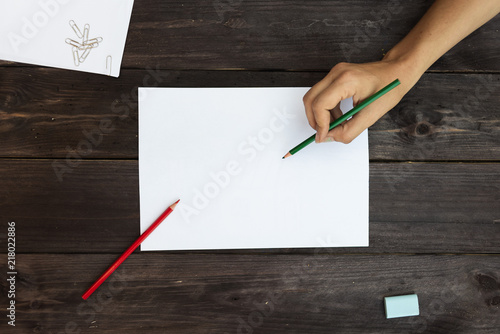 Foto obraz na płótnie canvas jednoczęściowy - A woman paints with colored pencils on a blank sheet