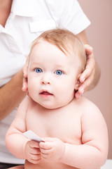 Little baby receiving osteopathic treatment of her head and neck