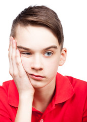 Bored teen boy with head on hand isolated on white