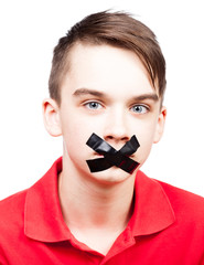 Speechless teen boy  with tape over his mouth