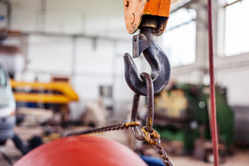 The load hangs on an old rusty iron hook, transportation, loading of goods, repair concept