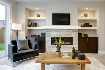 Beautiful modern living room interior with stone wall and fireplace in luxury home