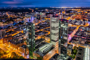 Die Hochhauskulisse von Frankfurt am Main am Abend bei künstlicher Beleuchtung