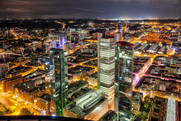 Die Hochhauskulisse von Frankfurt am Main am Abend bei künstlicher Beleuchtung