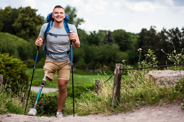 Overjoyed young man with prosthesis trying Nordic walking