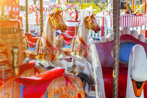 Zdjęcie XXL Dzieci plenerowi kolorowi rocznik karuzeli latający koński carousel w rozrywka wakacje parku w mieście. Przyciąganie szczegółów konie i zwierzęta z partii złoty lakier na tradycyjny karnawał retro