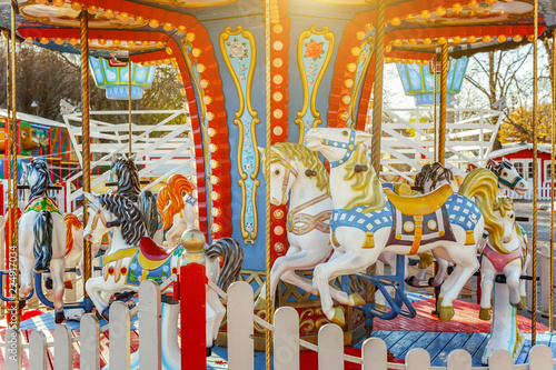 Zdjęcie XXL Dzieci plenerowi kolorowi rocznik karuzeli latający koński carousel w rozrywka wakacje parku w mieście. Przyciąganie szczegółów konie i zwierzęta z partii złoty lakier na tradycyjny karnawał retro