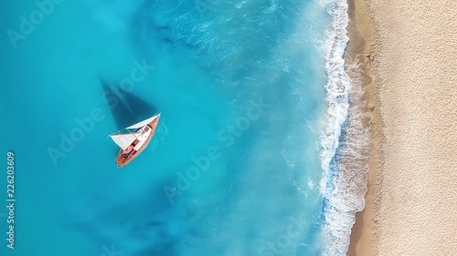 Yacht on the water surface from top view. Turquoise water background from top view. Summer seascape from air. Travel concept and idea © Biletskiy Evgeniy