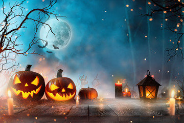 Halloween pumpkins on dark spooky forest.