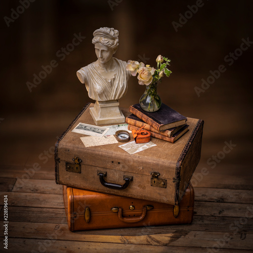 Still life with vintage suitcase, old letters, books and bust © marina