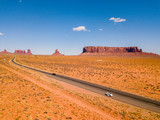 July 30, 2018. Monument Valley National Park, Utah, USA. White Ford Mustang parked by the side of the road at Monument Valley National Park with an amazing view on the infinite road through the desert