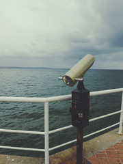 Telescope on the pier on wooden day