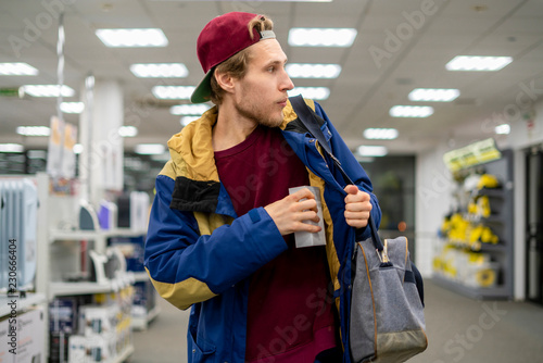 Zdjęcie XXL shoplifter w sklepie elektronicznym supermarket kradnie nowy gadżet f