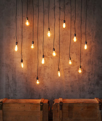 Edison light bulb background. Vintage lamps over concrete background.