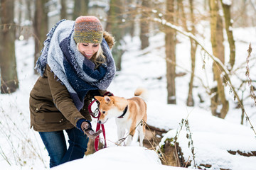 Frauchen und ihr Hund spielen im Schnee