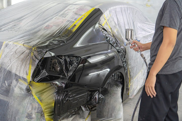 spray gun with paint for painting a car