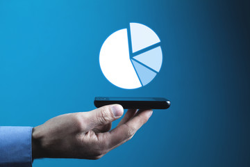 Hand holding phone with pie graph. Business concept