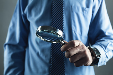 Businessman showing magnifying glass. Business concept