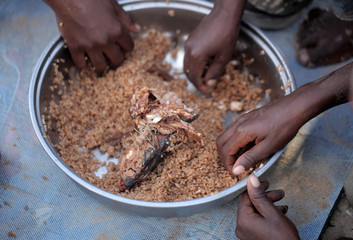 kids eating brown rice and fish in Africa - closeup
