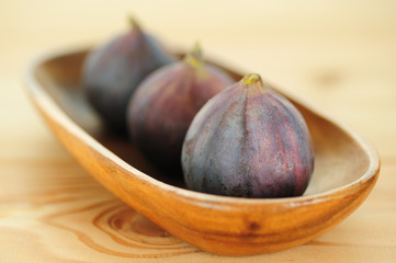 Close-up of raw figs in wooden bowl