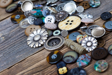 Vintage buttons in large numbers scattered on aged wooden boards