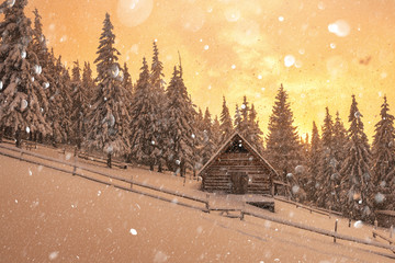 Fantastic pink evening landscape glowing by sunlight. Dramatic wintry scene with snowy house. Christmas holiday postcard collage. DOF bokeh light postprocessing effect