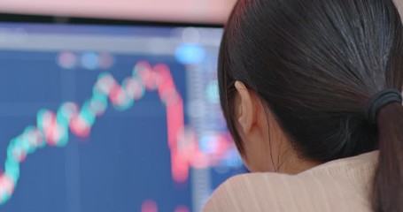 Woman work on computer with stock market at home