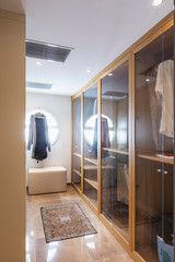 Walk-in closet in wood and marble with large round lighted window