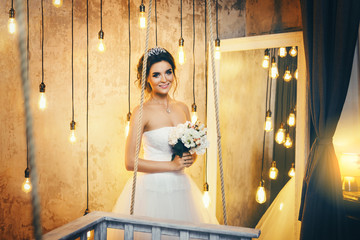 Young happy bride n the room with a lot of light bulbs