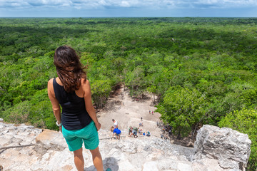 Touristin schaut von der Spitze der Nohoch Mul Pyramide in Coba, Mexiko, über den Regenwald und genießt die Aussicht