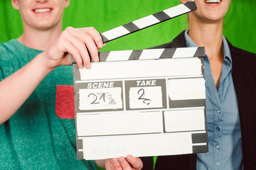 Assistant holds movie slate into the camera to start the production of a video piece