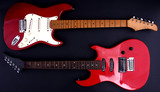 Red electric guitar with a black background.