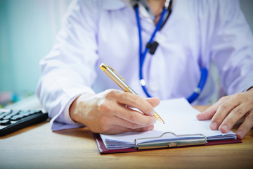 doctor taking notes or fills in the client's medical card or prescribes medication