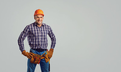 Repairman in special clothes on a gray background.