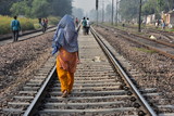 インドの首都のデリー 線路を歩く人々 サリーを着たインド人女性の後ろ姿