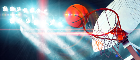 Deportes y entretenimiento. Baloncesto y deportes de equipo.Canasta  y pelota iluminados por los focos. Partido y evento deportivo. Público y multitud aplaudiendo el partido de baloncesto.