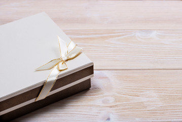 Gift box on wooden light background. Space for text