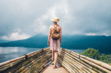 Traveller woman with a backpack looking at the amazing landscape travelling the world