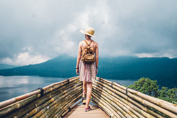Traveller woman with a backpack looking at the amazing landscape travelling the world 