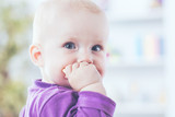 portrait of a happy one year old baby girl on a background of bright children's room